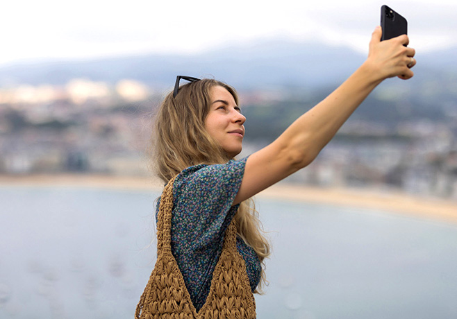 Chica mirando su smartphone contratado con la oferta barata fibra y móvil de Euskaltel